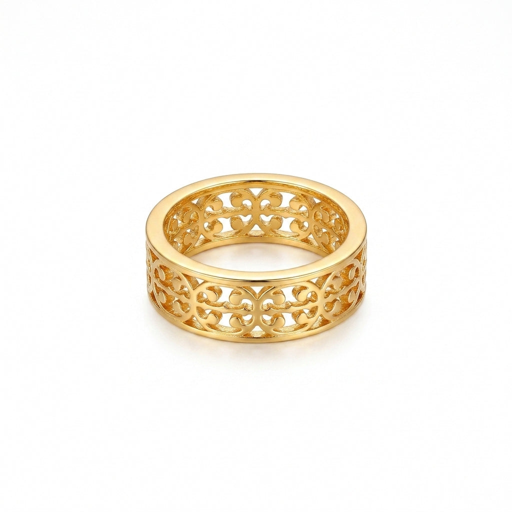 A gold filigree band ring with an intricate openwork pattern, shown on a clean white background.