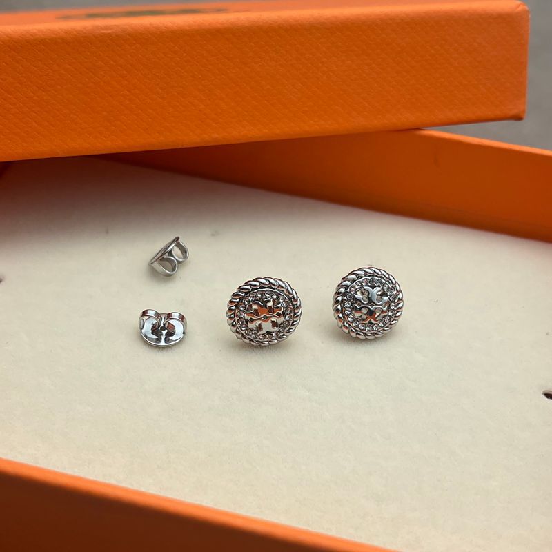 Both earrings displayed face-up on a dark, smooth surface (black marble), highlighting the contrast between the textured rope border and crystal sparkle.