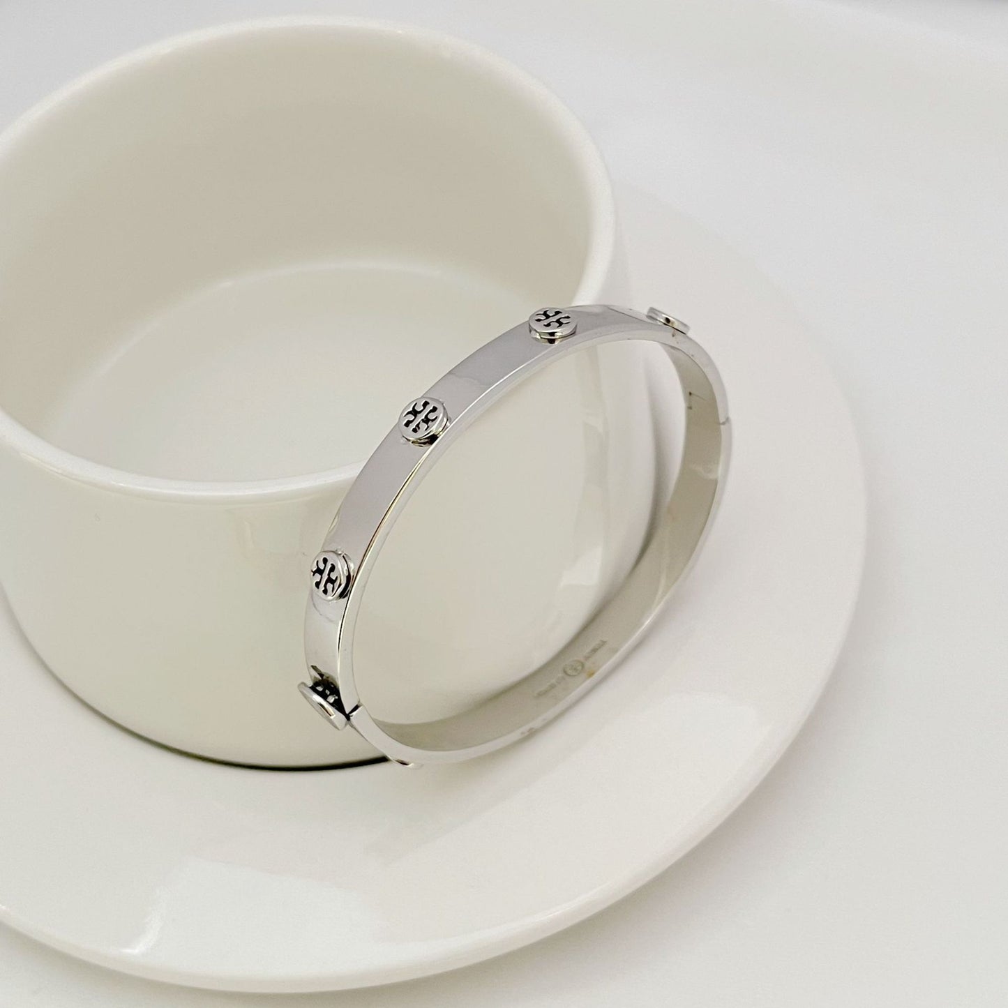 Bracelet displayed open on a dark velvet background, emphasizing the continuous line of pave crystals and sleek metal band.