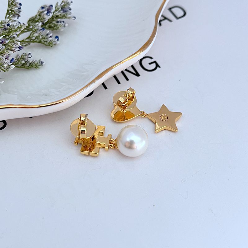 Image showing a model wearing the pearl on one earlobe, the heart on the other, and the star perhaps on a upper cartilage or as a second lobe stud (if designed for multiple piercings).