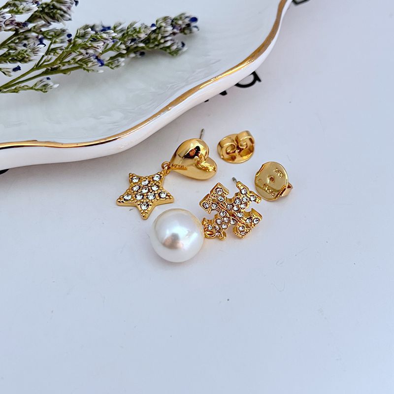 Image showing a model wearing the pearl on one earlobe, the heart on the other, and the star perhaps on a upper cartilage or as a second lobe stud (if designed for multiple piercings).