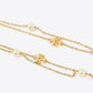 A gold chain necklace featuring small gold puzzle-piece charms and white pearl beads, displayed on a clean white background.