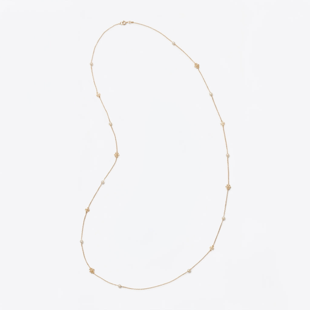 A delicate gold chain necklace featuring small, evenly spaced gold star charms, displayed on a clean, light gray background.