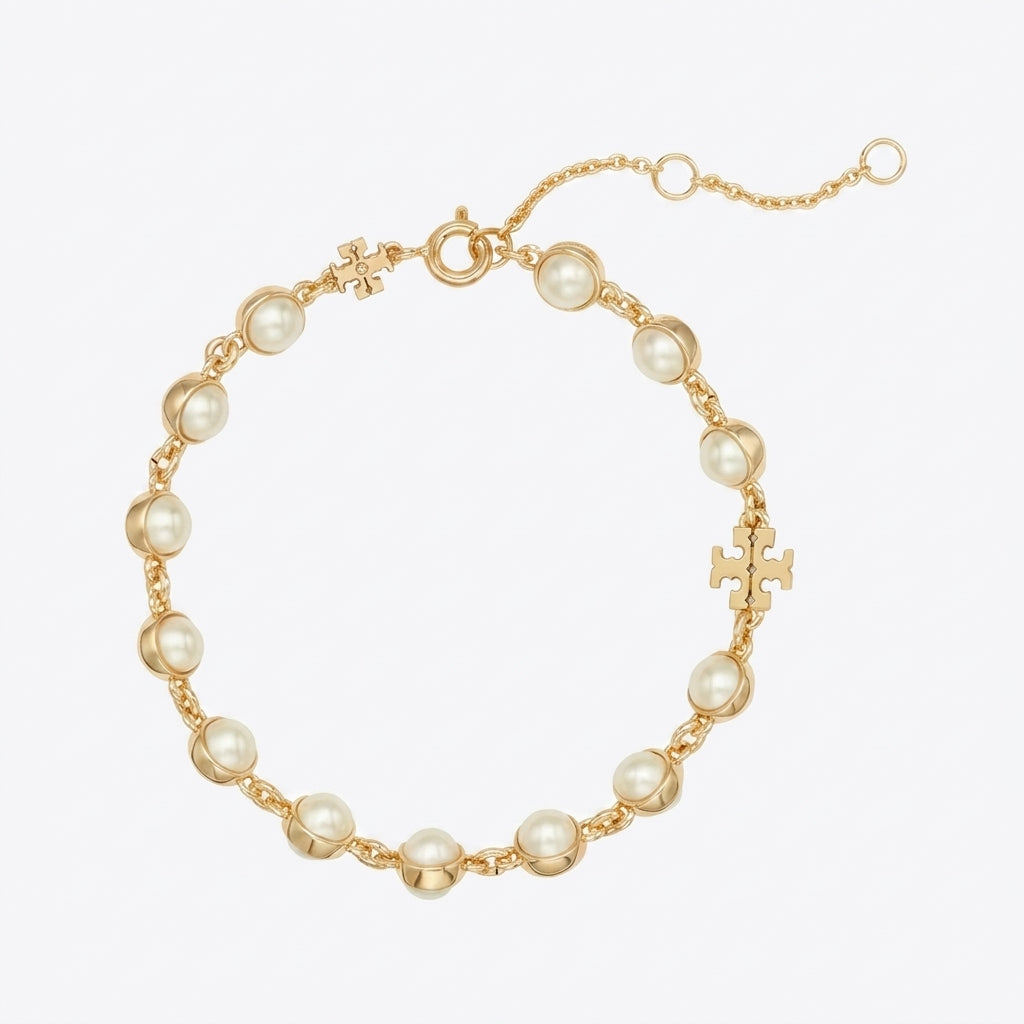 A gold chain bracelet featuring round white faux pearls and small gold cross charms, displayed on a clean white background.