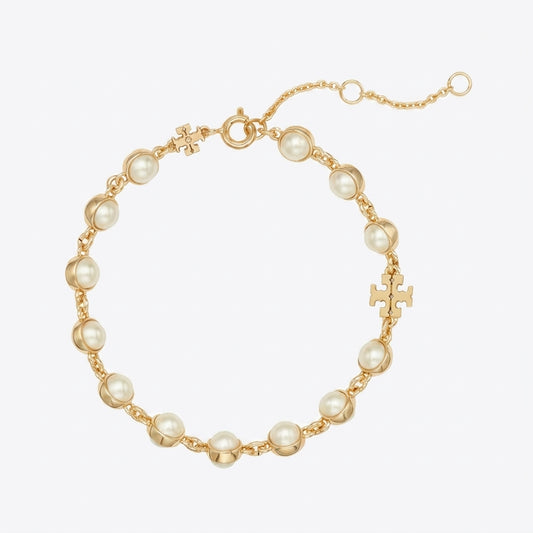 A gold chain bracelet featuring round white faux pearls and small gold cross charms, displayed on a clean white background.