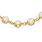 A close-up of a gold chain bracelet featuring large, round white freshwater pearls set in polished gold bezels, shown against a plain white background.