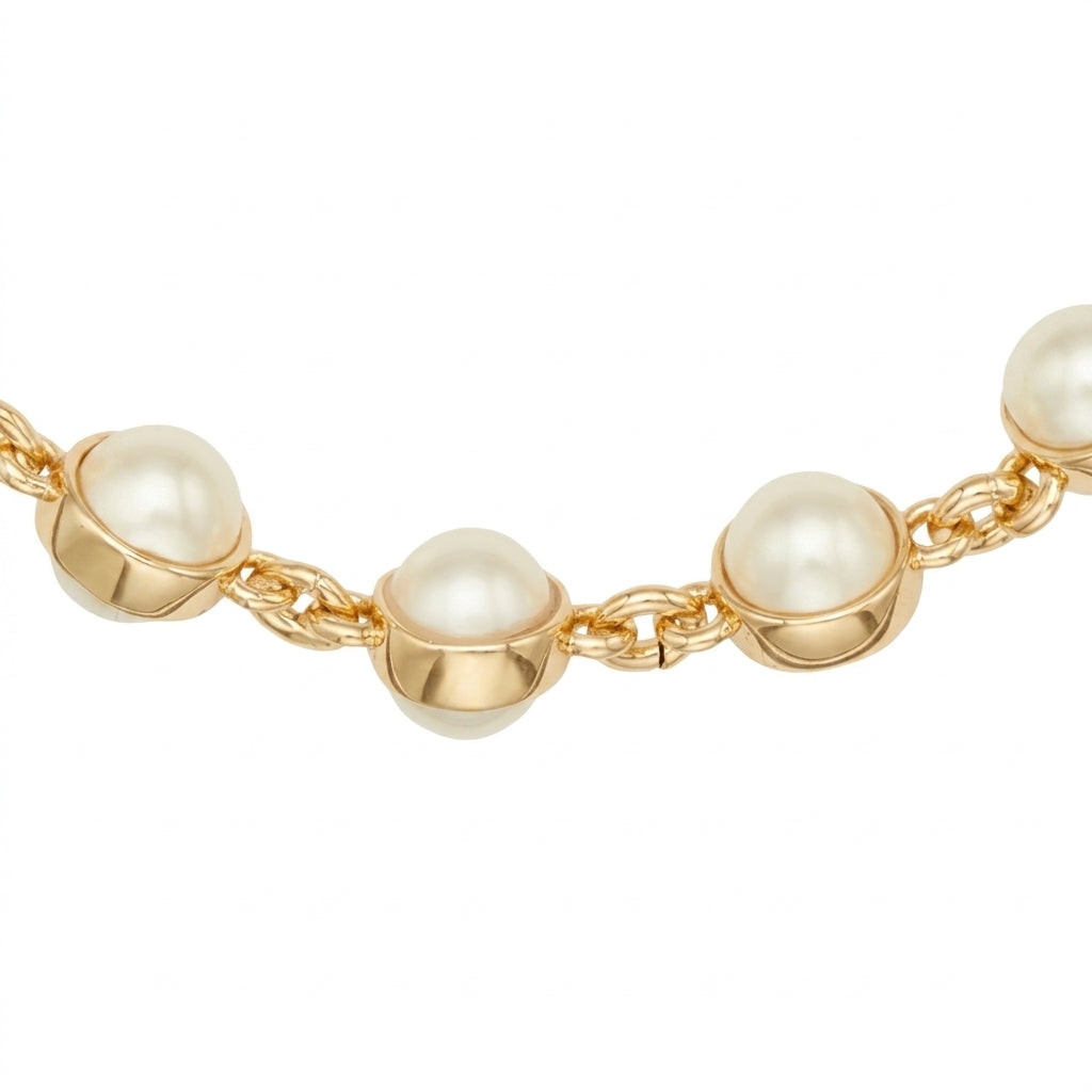 A close-up of a gold chain bracelet featuring large, round white freshwater pearls set in polished gold bezels, shown against a plain white background.
