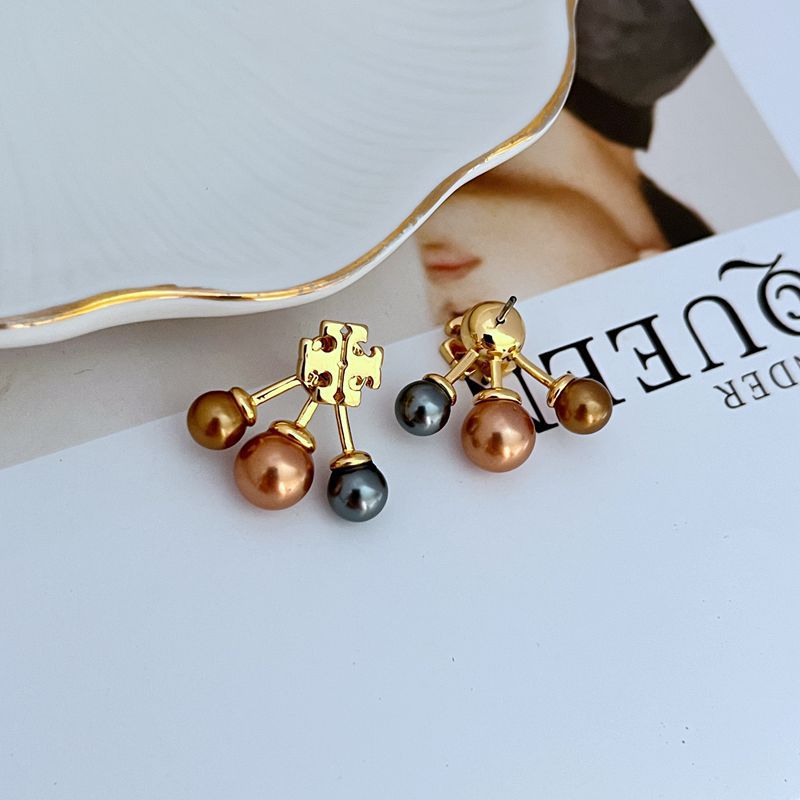 One earring shown with the pearl side facing up, and the other with the celestial side facing up, arranged side-by-side on a neutral background.