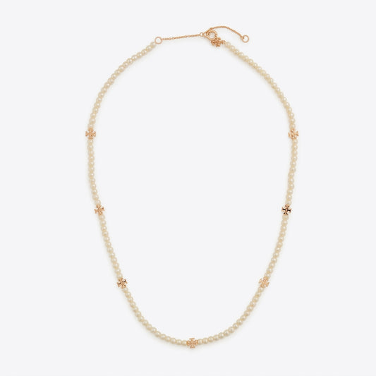 A delicate pearl necklace with rose gold star-shaped accents, displayed on a clean, light gray background.