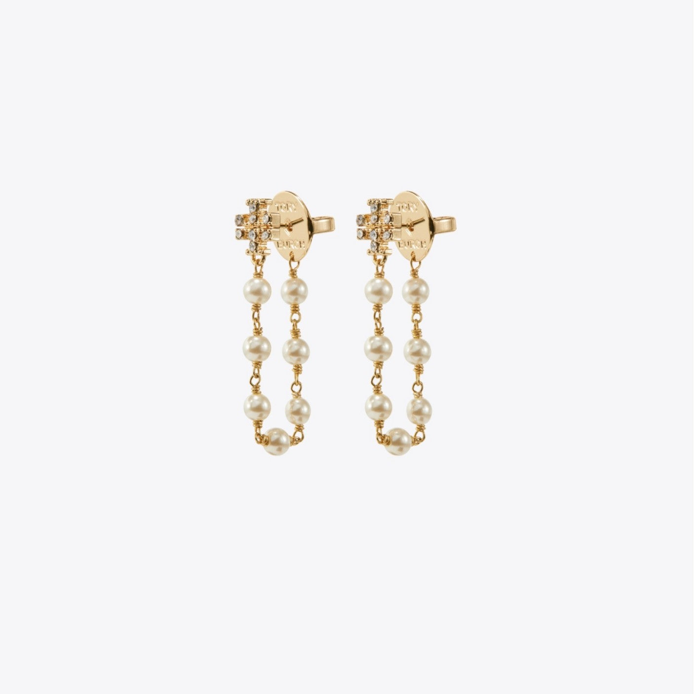 Gold earrings with pearl chains on a white background