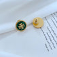 Gold and green earring on a book page