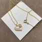 Close-up focusing on the heart shape, highlighting the natural iridescent play of color in the mother of pearl and the gold-tone setting.