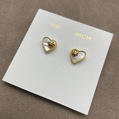 The necklace and earrings displayed together on a soft, light background (gray velvet or linen), showcasing the matching heart designs and iridescent pearl finish