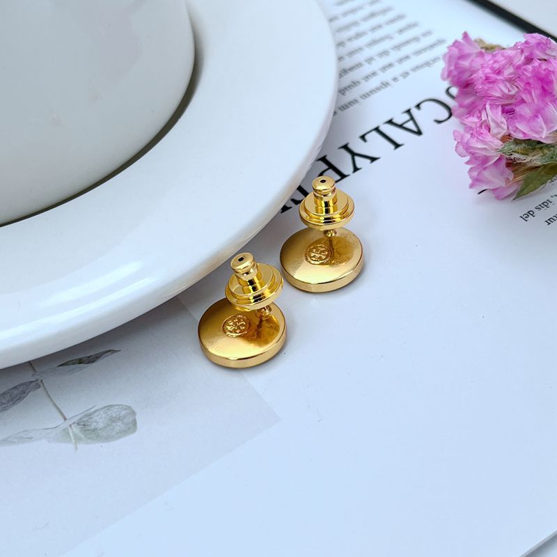 Clean shot of a single stud against a soft, neutral background, showcasing the beautiful iridescent colors of the mother-of-pearl and the gold setting.