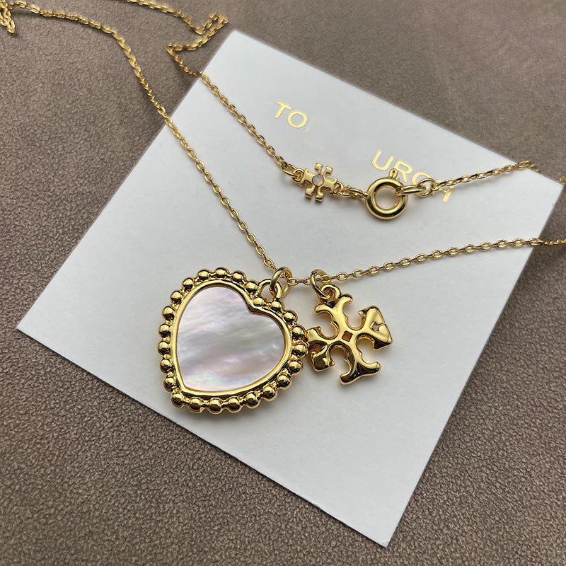 Close-up focused on the heart and Double T charms side-by-side, highlighting their shapes, polished finish, and any engraved details.