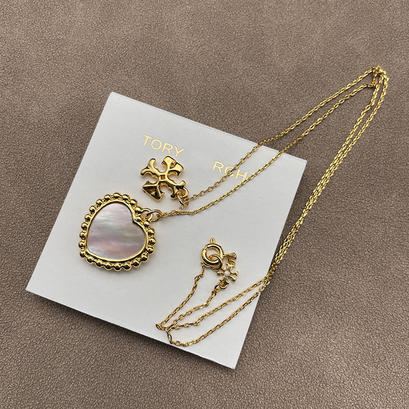 Necklace laid flat on a soft, neutral background (light gray linen), clearly showing both pendants spaced evenly along the chain.