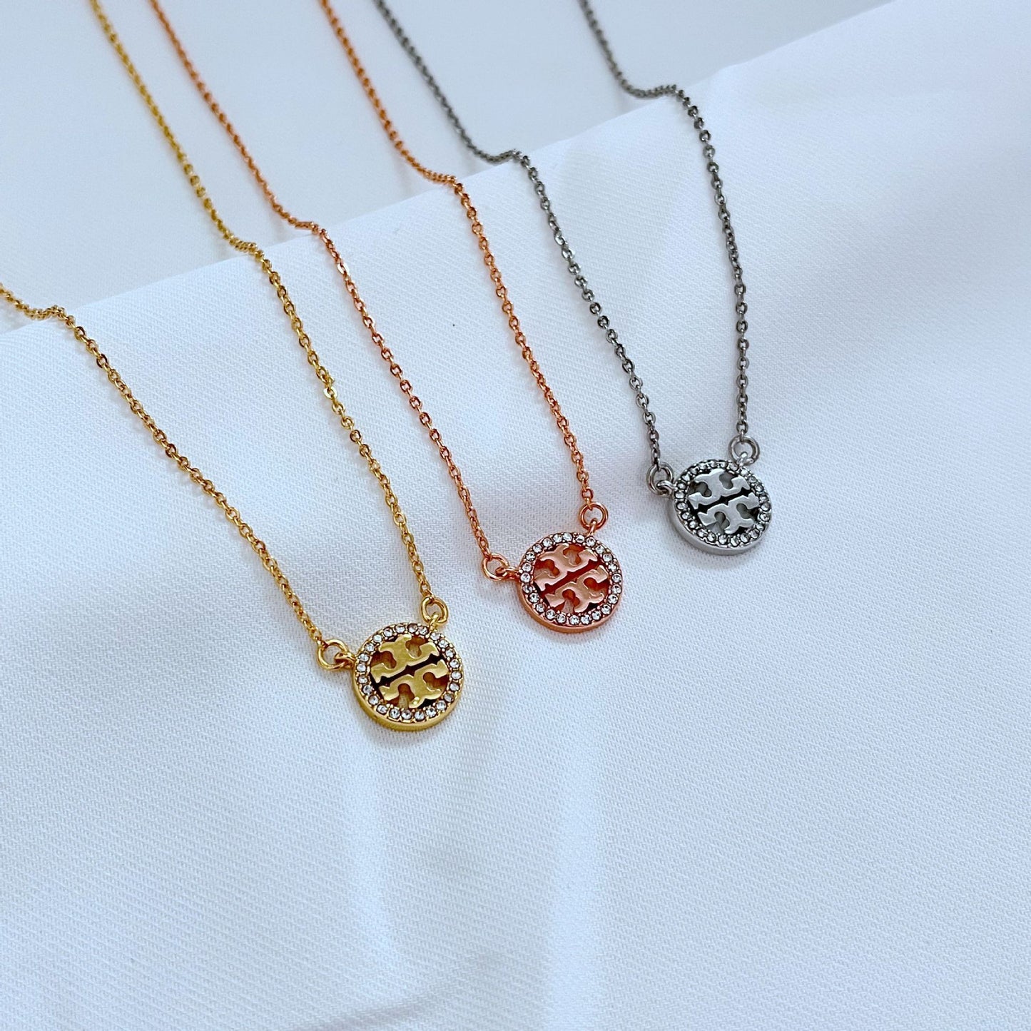 Necklace displayed on a dark, non-reflective surface (black velvet or slate), highlighting the intense sparkle of the crystals against the rich gold plating.