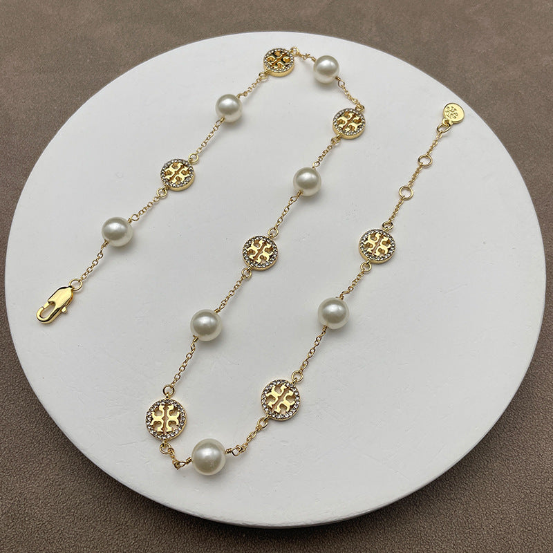 Necklace laid flat on a muted, textured background (e.g., gray slate or linen), highlighting the contrast between the organic pearl and the sparkling pave details.