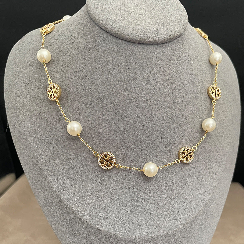 The necklace worn with both a crisp white shirt (day) and a simple black top (evening) to demonstrate its versatile elegance.