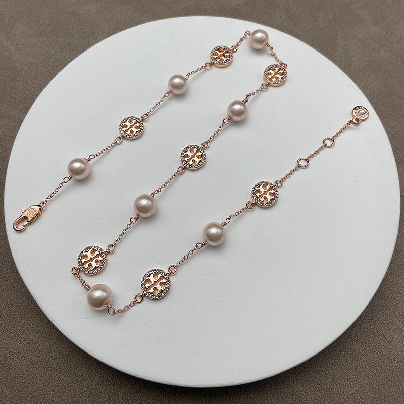 Necklace laid flat on a muted, textured background (e.g., gray slate or linen), highlighting the contrast between the organic pearl and the sparkling pave details.