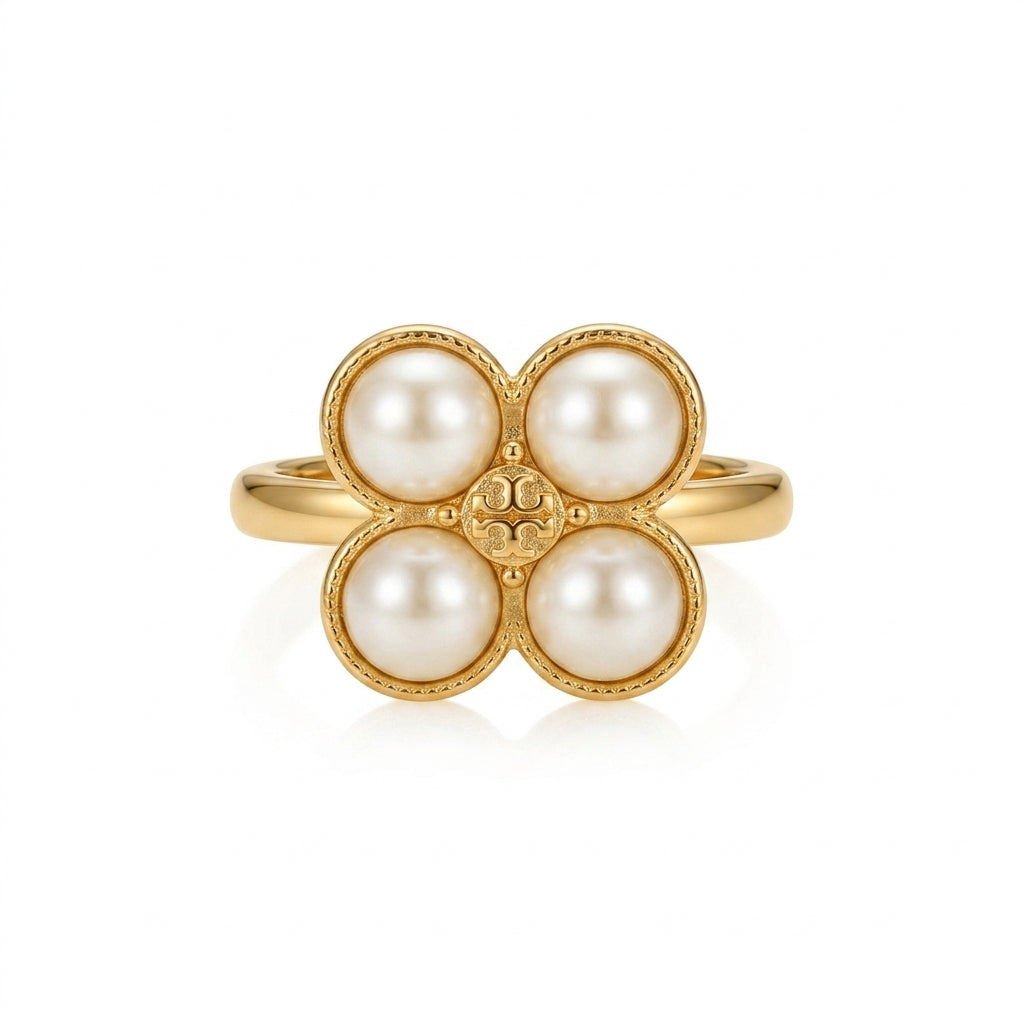 A gold ring featuring four round white pearls arranged in a flower-like cluster, set against a clean white background.