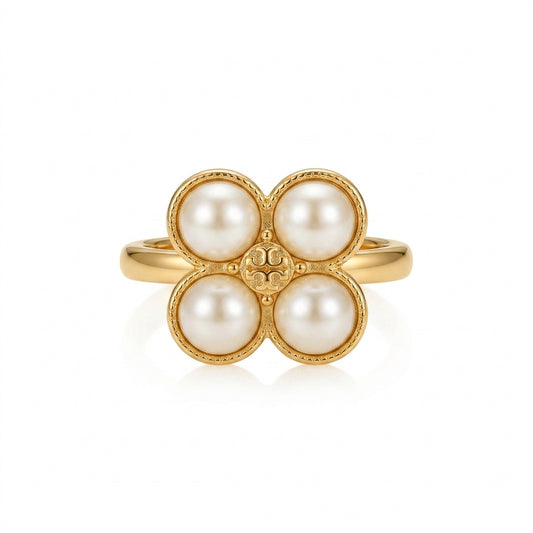 A gold ring featuring four round white pearls arranged in a flower-like cluster, set against a clean white background.