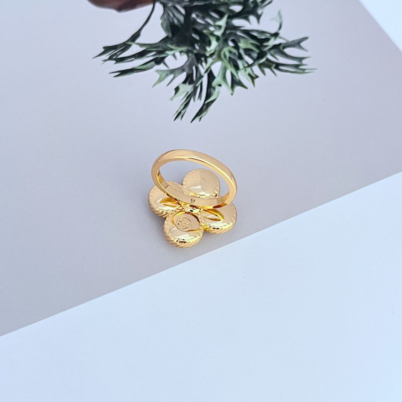 Clean shot of the ring on a simple background, showcasing the clover shape and the four pearls.
