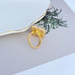 Clean shot of the ring on a simple background, showcasing the clover shape and the four pearls.
