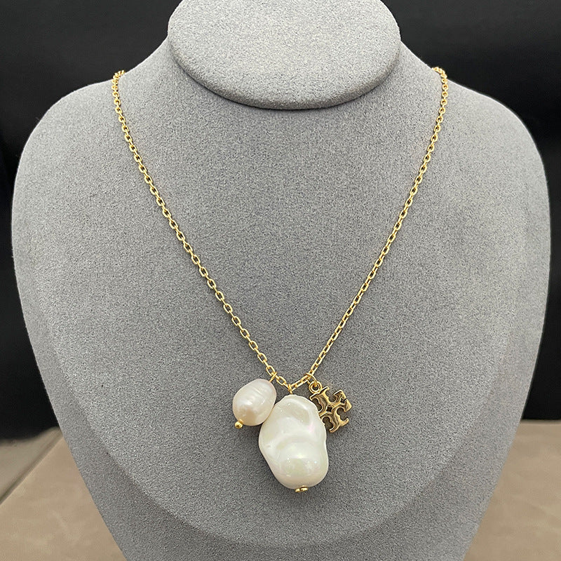 Both earrings displayed face-up on a soft, neutral background (light gray or ivory suede), highlighting the pearl’s luster and gold setting.