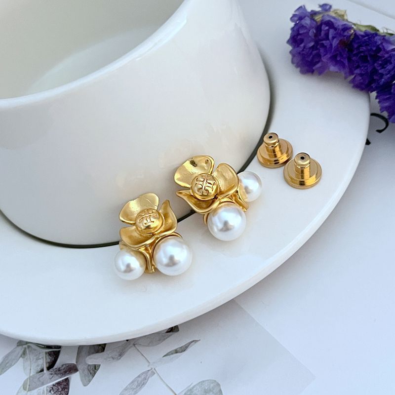 Clean, high-resolution front-facing shot of a single earring, showcasing the floral detail surrounding the central pearl against a soft, neutral background.