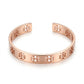 A rose gold cuff bracelet with a repeating geometric cutout pattern, displayed on a clean white background.