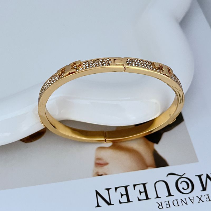 Focus on any Tory Burch logo, engraving, or texture detail, emphasizing craftsmanship.