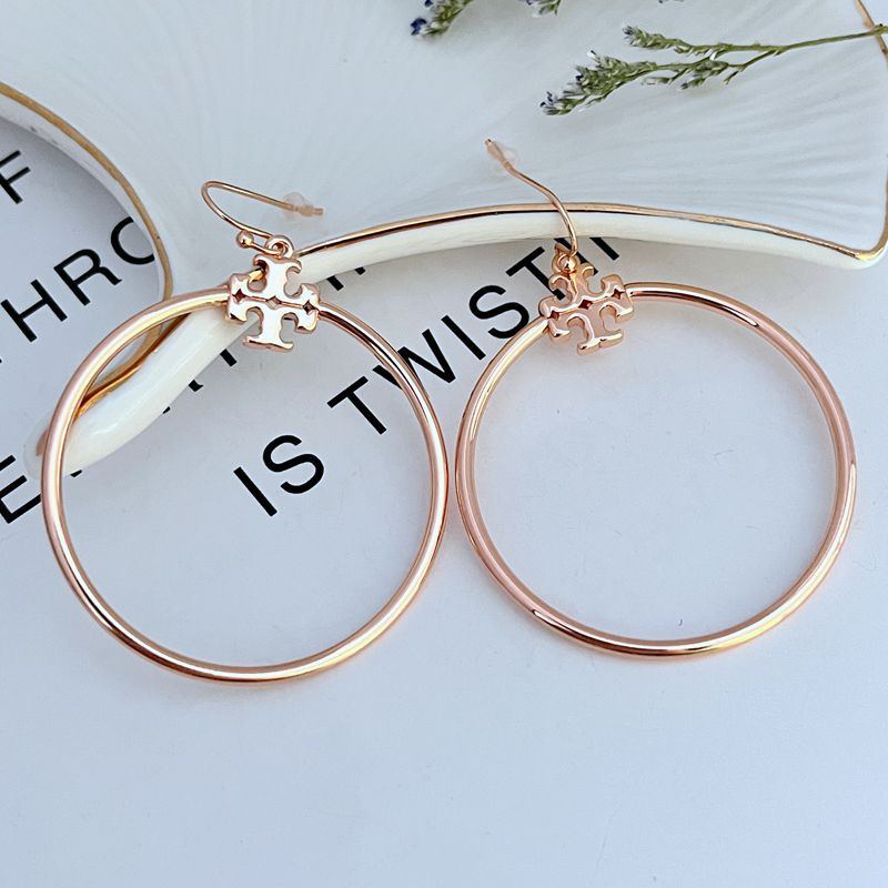 Tory Burch Rose Gold T Logo Hoop Earrings on a neutral background, showcasing the iconic logo and warm rose gold tone."