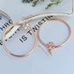 Tory Burch Rose Gold T Logo Hoop Earrings on a neutral background, showcasing the iconic logo and warm rose gold tone."
