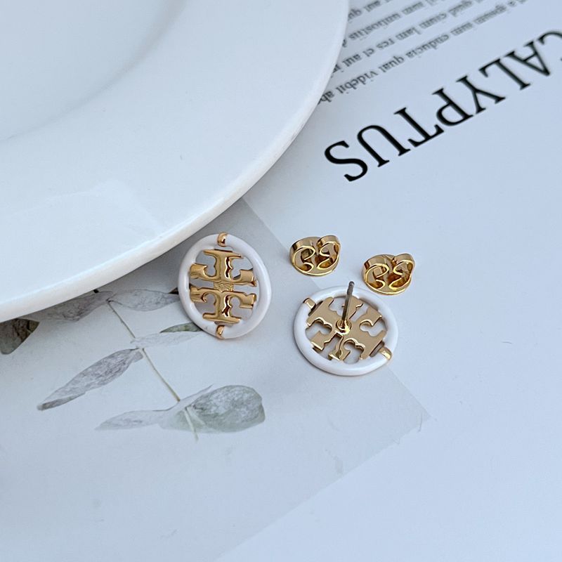  Clean, front-facing shot of a single hoop against a solid, contrasting background (like dark grey or black), emphasizing the stark, graphic divide between the white enamel and gold halves.