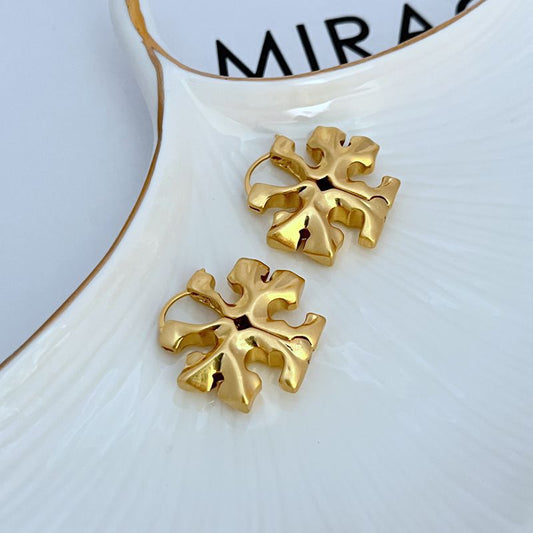 Both earrings displayed hanging against a plain background, with a focus on the hidden latch area and the dangling Double T charm.