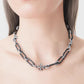 The necklace worn with a crewneck top or open collar, showing how it sits snugly at the base of the neck for a modern, tailored look.