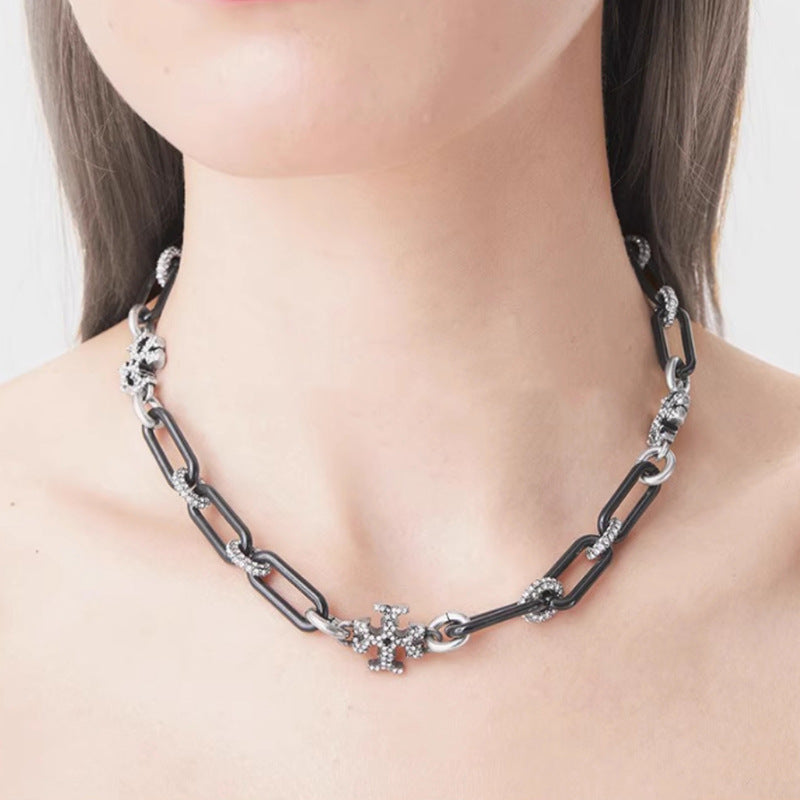 The necklace worn with a crewneck top or open collar, showing how it sits snugly at the base of the neck for a modern, tailored look.