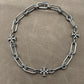 Necklace laid flat on a cool-toned background (e.g., slate gray or white marble), highlighting the silver sheen and clean lines of the chain and pendant.