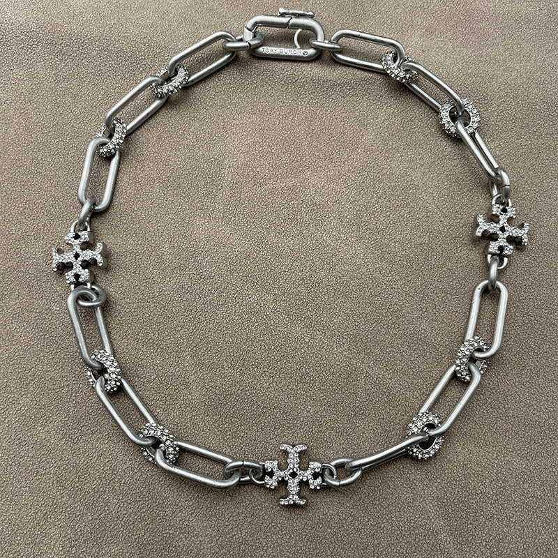 Necklace laid flat on a cool-toned background (e.g., slate gray or white marble), highlighting the silver sheen and clean lines of the chain and pendant.