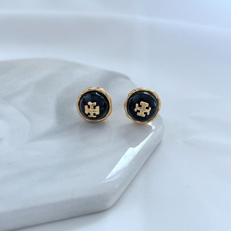 The earrings placed on a raw crystal cluster, a bed of sand, or alongside other natural materials, emphasizing the connection to organic beauty and artisan inspiration.