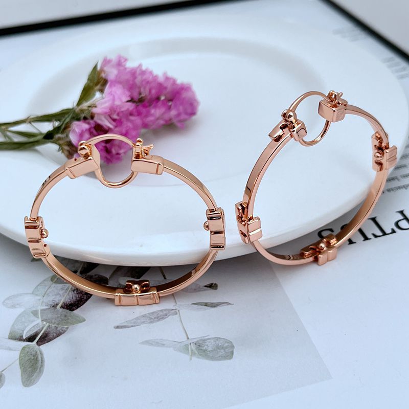 "Tory Burch Serif T Gold Plated Hoop Earrings isolated on a clean white background, showcasing the double T logo and perfect circular shape."