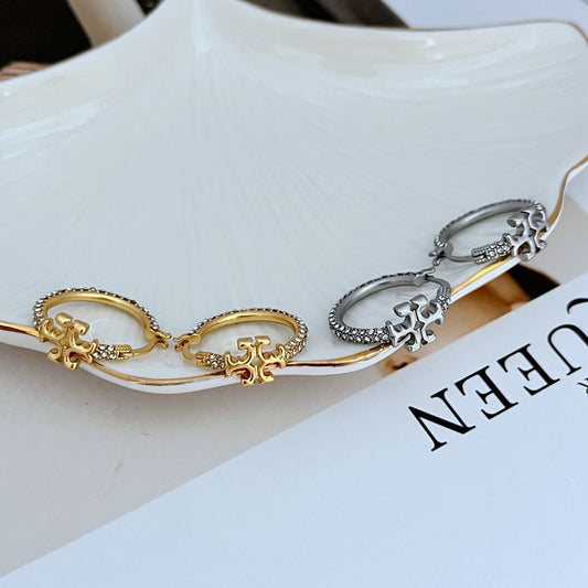 Both hoops displayed hanging or laid flat on a neutral background, clearly showing the hoop shape and attached TB monogram.