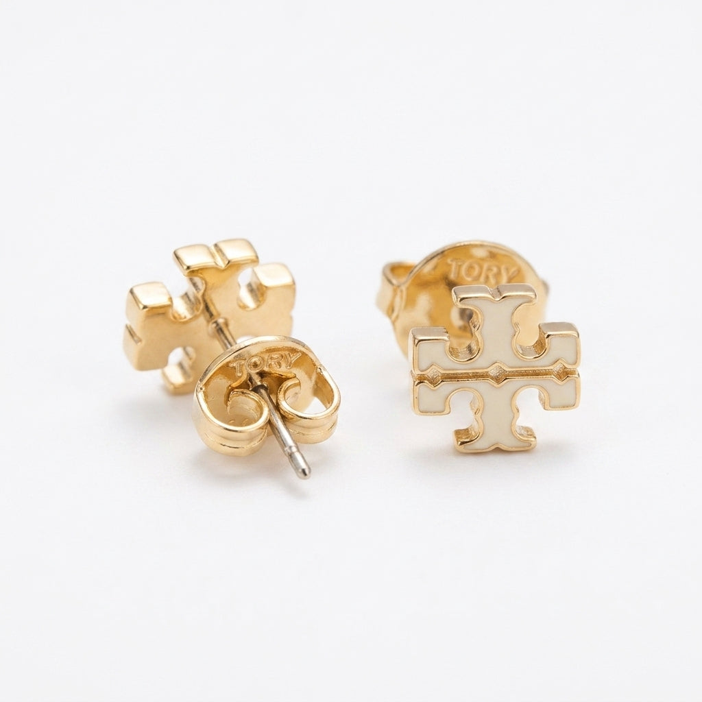 A pair of gold-tone stud earrings with a cross motif, shown on a clean white background. One earring is displayed from the front, showing the cross design, while the other is angled to show the post and backing.