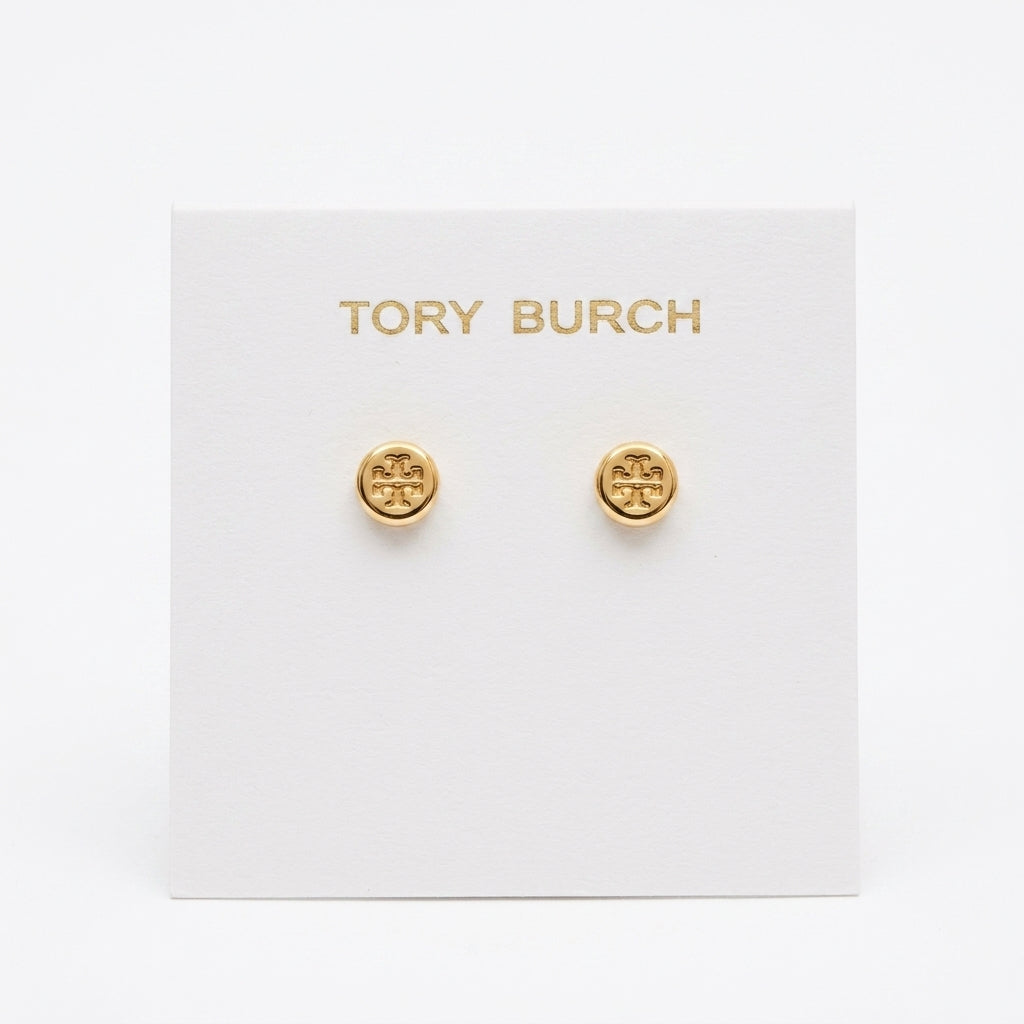 A pair of gold stud earrings with the Tory Burch logo, displayed on a white brand card against a white background.