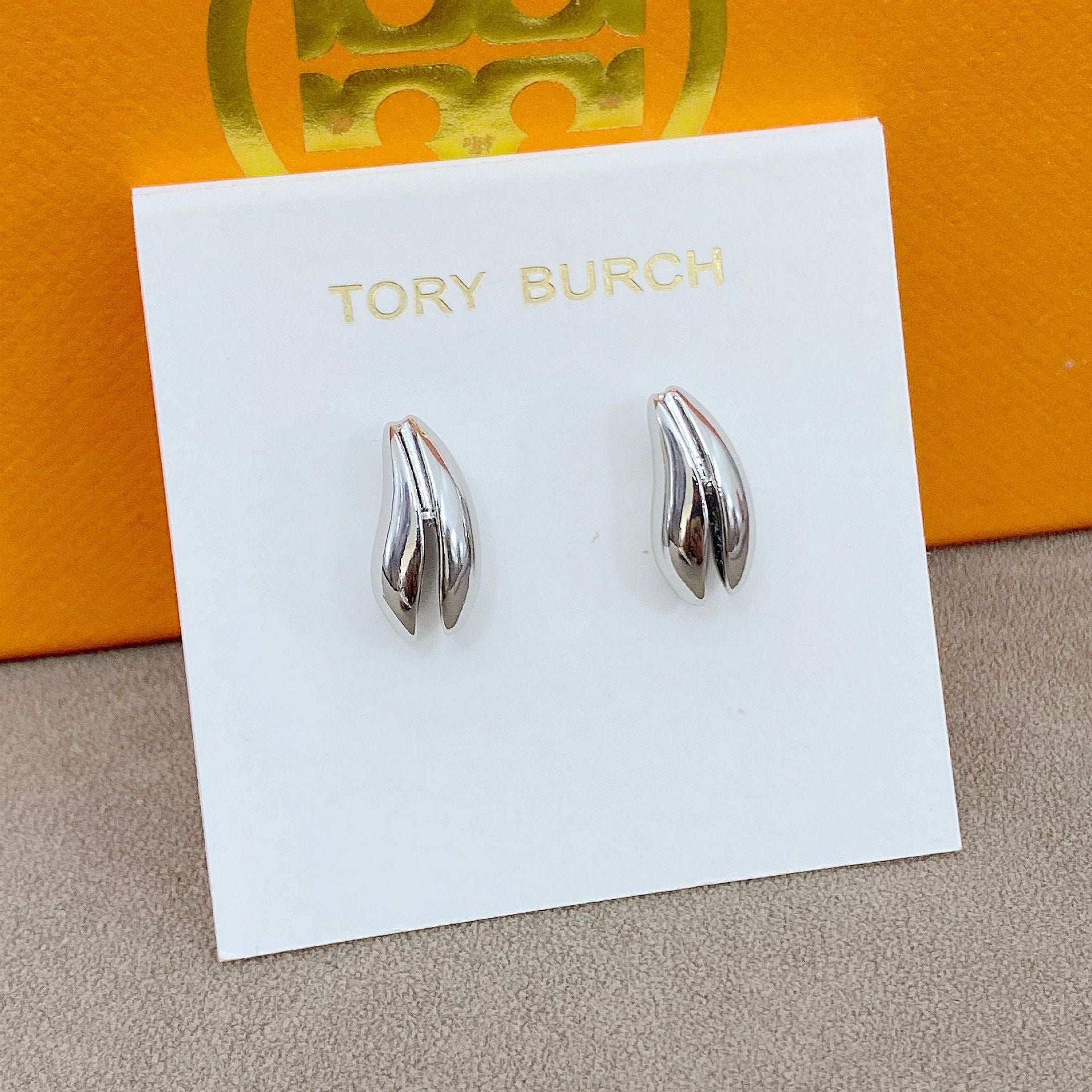 High-definition shot of the pair of earrings laid flat on pure white background, arranged symmetrically.