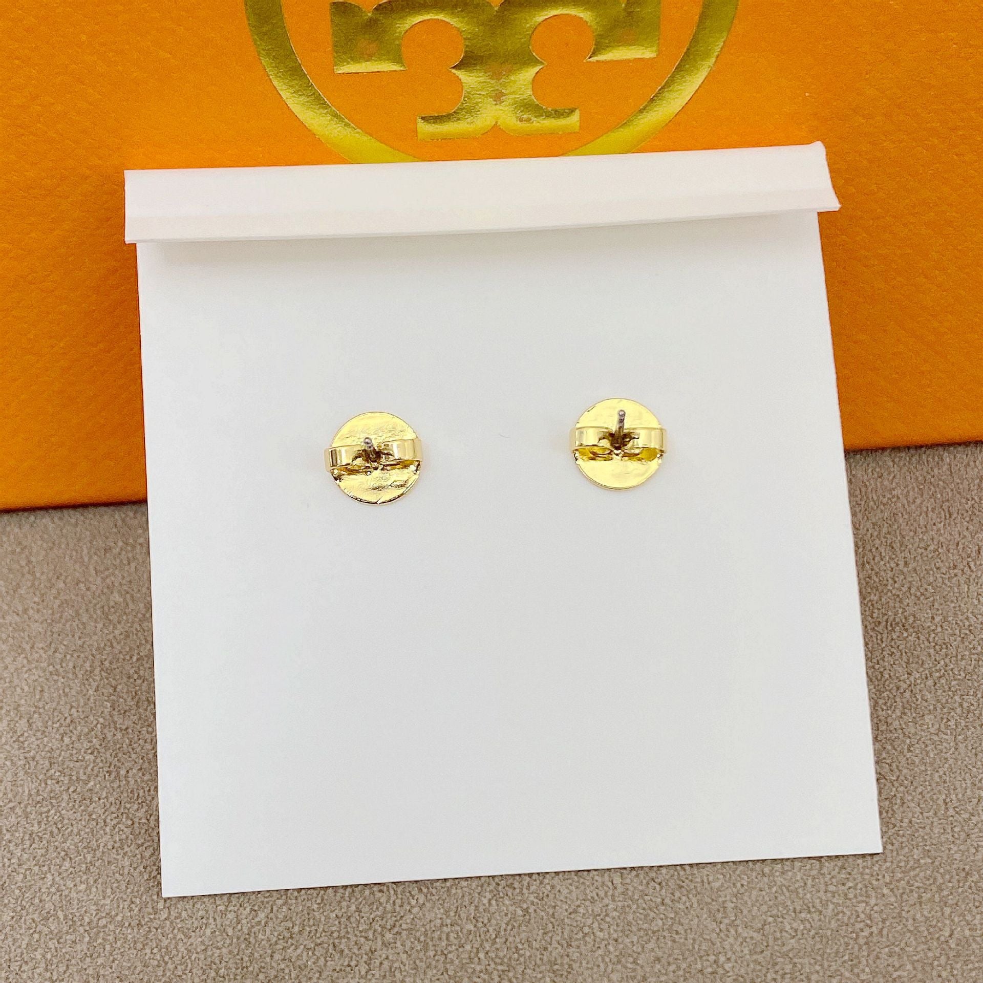 High-definition shot of the pair of earrings laid flat on pure white background, arranged symmetrically.