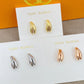 High-definition shot of the pair of earrings laid flat on pure white background, arranged symmetrically.
