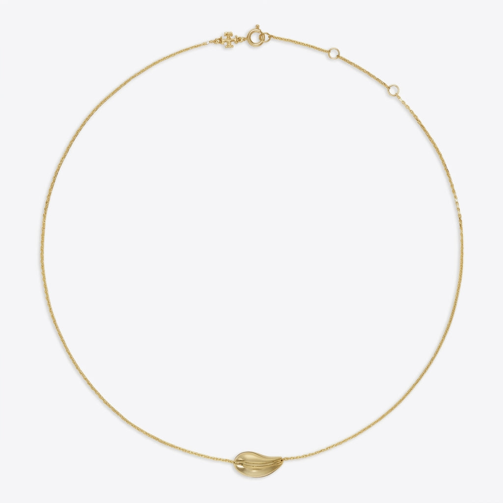 A delicate gold chain necklace with a small, polished gold leaf-shaped pendant, displayed on a clean, light gray background.