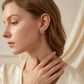 Close-up of a woman wearing gold earrings with a neutral background